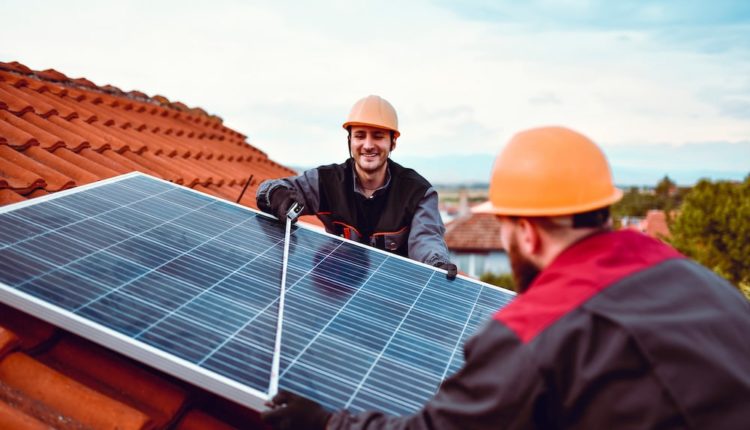 Workmen checking solar panel width.