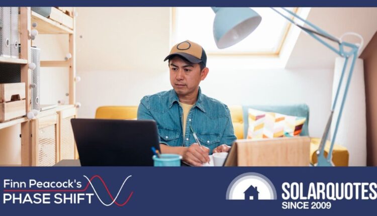 A man working from home with a sofa behind him